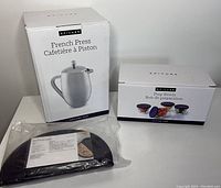 Photo showing boxed French Press, boxed set of 4 prep bowls with lids, and packaged black omelet maker.