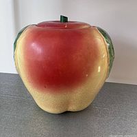 Front view of the ceramic apple cookie jar showing red and yellow gradient coloring and natural crazing on the glaze.