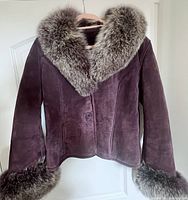 Front view of dark brown genuine leather coat with fluffy removable real fox fur collar and cuffs.