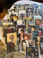 Photo showing an overview of the collection, multiple rock CDs fanned out on a table with visible album art including Cream, Joe Cocker, and Johnny Cash.