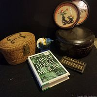 Overall lot with book, woven basket, ceramic elephant, wooden box, abacus, and two decorative plates.