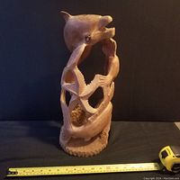 Front and side images showing the detailed carving of ocean creatures such as a dolphin and starfish, with a measuring tape indicating height around 12 inches.