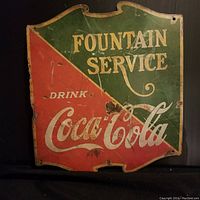Full view of vintage Coca-Cola metal sign with Fountain Service branding, showing condition and design details.