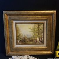 Frontal view of the small vintage/oil painting in a gold-colored frame against a black background.