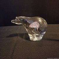Side view of clear glass Spirit Bear figurine showing internal color design and shape.