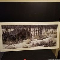 Full view of the framed winter landscape print showing snow, trees, and wolf