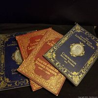 Three hardcover Illustrated London News magazines arranged stacked, showing decorative covers with gold embossing referencing Coronation and Silver Jubilee editions.