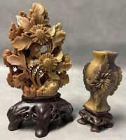 Front view of the two Shoushan stone sculptures showing detailed floral carving and wooden stands.