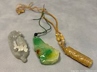 Three pendants arranged on grey surface with cords visible