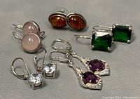 Photo of all five pairs of 925 silver earrings with semi-precious stones: rose quartz, amber, green stones, amethyst, and cubic zirconia showing style and size variety.