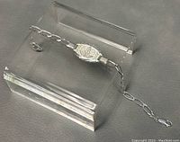 Full view of 8.5 inch sterling silver medic-alert bracelet laid flat on gray surface with acrylic stands