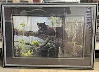 Framed print with visible art showing a black panther on a tree branch surrounded by jungle foliage, overall view of the item.