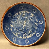 Top-down view of the 10-inch Japanese porcelain plate featuring the blue phoenix transferware design and orange-brown scalloped edge.