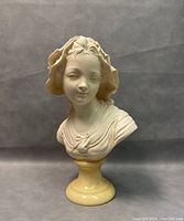 Front view showing facial features, drapery and pedestal