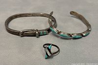 Three sterling silver pieces including a ring, hinged bangle, and cuff bangle with turquoise inlay