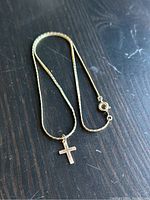 Full necklace with cross pendant displayed on dark wood background