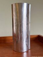 Photo showing the cylindrical pewter vase with etched birch leaf detailing on smooth polished metal surface.