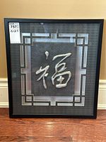 Front view of framed Chinese art print featuring embossed silver Chinese character in black frame.