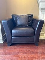 Front view of leather armchair showing overall shape and cushions