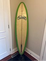 Full view front deck of the vintage Slider surfboard with green border and branding