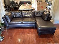 Full view right-facing sectional sofa on hardwood floor with back cushions and chaise on right side