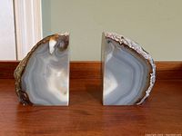 Front view of the pair showing polished, gray and white banded faces and rough outer edges.