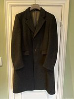Front view of vintage men's grey wool and cashmere overcoat hanging on hanger in good condition.