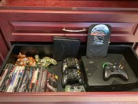 The open drawer showing the original Xbox console, controllers, and games in cases.