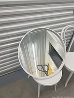 Front view of the round mirror showing clear reflective glass surface and white frame.