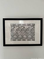 Front view of the framed black and white floral print centered on a wall.