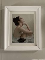 Front view of the framed print featuring a woman and paper boats.