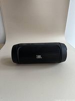 Front view of black JBL portable Bluetooth speaker on white background showing JBL logo on speaker grille.