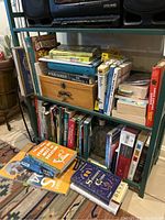Full view of multiple shelves with books related to gardening, murder mysteries, birds, houseplants, rocks, and religion plus a small wooden chest box.