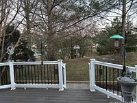 View of deck with bird feeders and solar deck light on railing posts