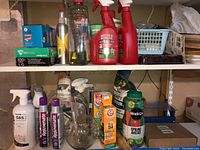 Photo of gardening supplies on shelves, including spray bottles, boxed items, and household cleaning products.