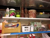 Photo of shelves showing various gardening chemicals, pots and decorative items.