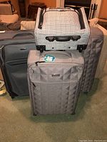 Full view of the four luggage pieces arranged together, showing different sizes and colors.