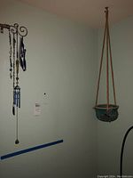 Wind chimes with decorative pendants hanging on left side, green hanging planter suspended from ceiling on right side.