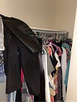 First image shows a black leather skirt and several assorted dresses and blouses in multiple colors and patterns hanging on a rack.