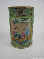 Front view showing Chinese figures and floral decoration on green ground.