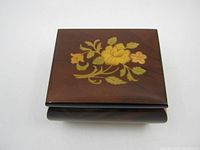 Top view of wooden music box showing floral inlay on lid.