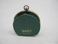 Front view of the vintage green leather coin purse with gold Neiman Marcus logo and Made in Spain text.