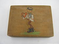 Top view of the hand painted wooden box showing figure holding heart on lid.