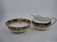 Both sugar bowl and creamer shown side-by-side with clear view of detailed cobalt blue and gold pattern with floral accents.