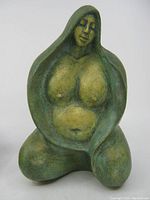 Front view of the ceramic figurine showing the woman's face, chest, and seated posture