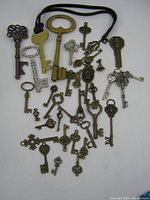 Photo showing a spread of old skeleton keys in various styles and sizes, some attached to a black cord.