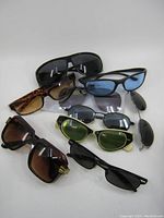 Full view of all nine pairs of sunglasses and clip-on glasses showing different frame and lens styles.