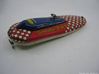 Full length side and top view of the vintage Sweetie Pie 55 tin toy boat showing checkerboard and lettering design.