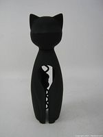 Front view of the black cat shaped corkscrew showing the full silhouette and the spiral corkscrew in the center opening.