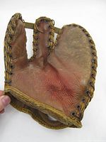 Front view showing worn brown leather, two finger stalls, lacing, and interior wear.